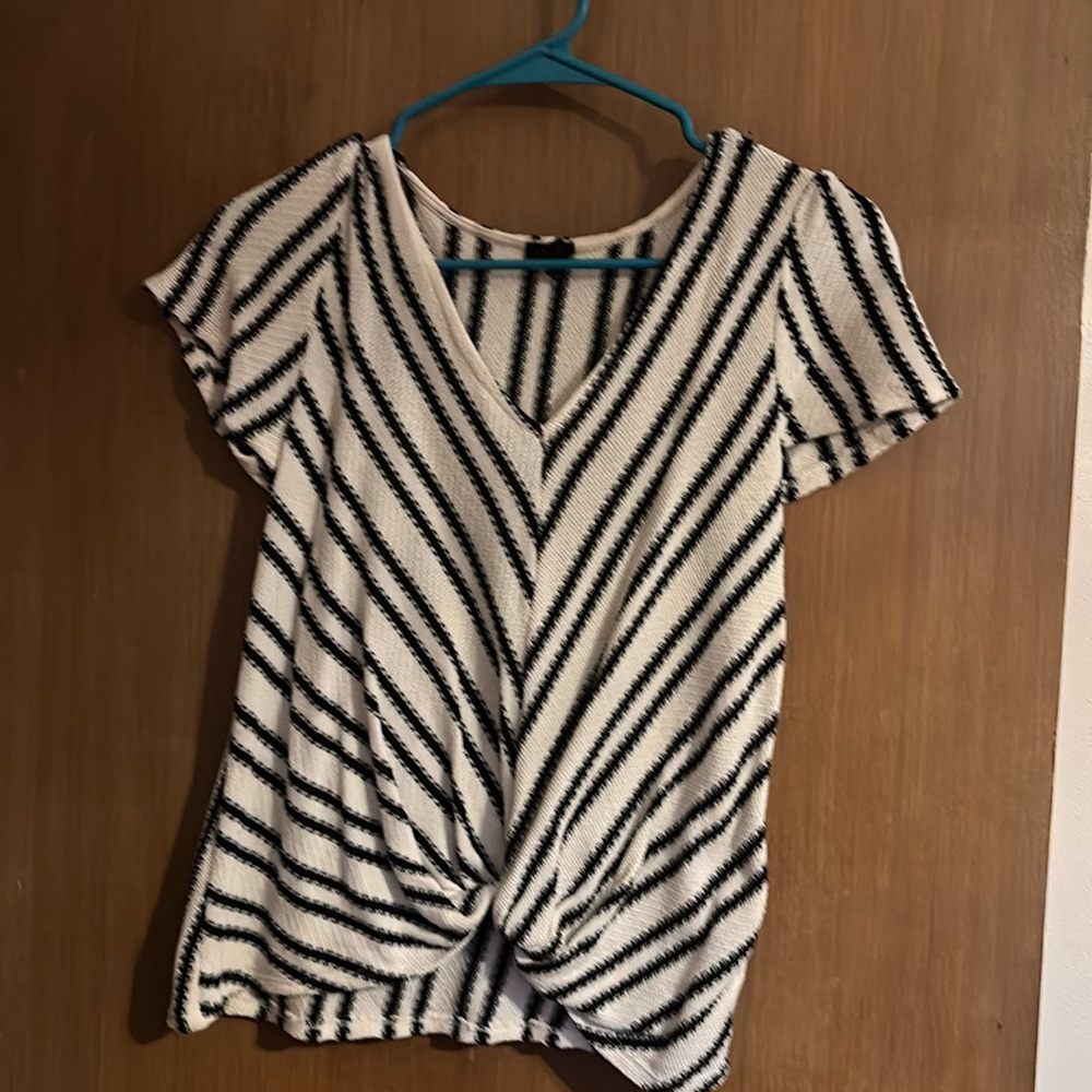 Cream and black knitted short sleeve sweater that’s twisted at the bottom.